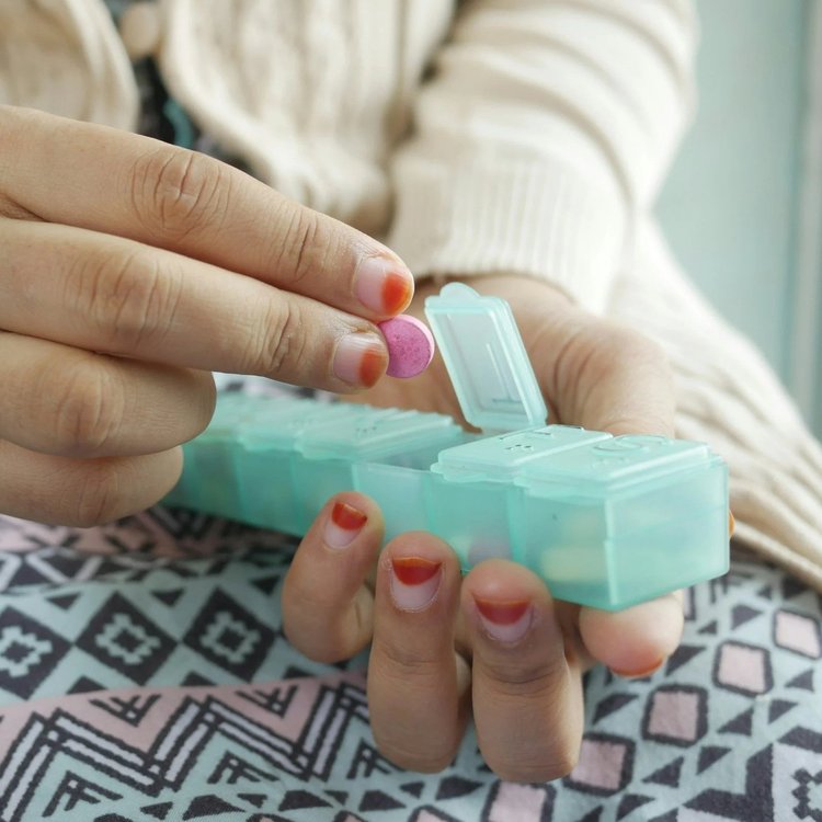 Hands holding a pill organizer